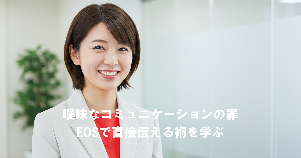白いスーツに赤いインナーを着た女性リーダーが笑顔で立っている。画像内には「曖昧なコミュニケーションの罪 EOSで直接伝える術を学ぶ」という文字が表示されている。