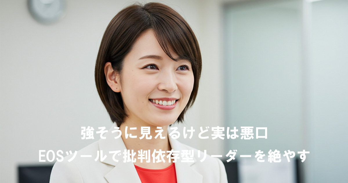 白いスーツに赤いインナーを着た女性リーダーが笑顔で前を見つめる。記事タイトル「強そうに見えるけど実は悪口｜EOSツールで批判依存型リーダーを絶やす」を表現したイメージ。