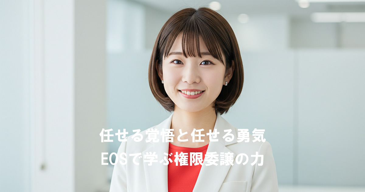 白いスーツに赤いインナーを着た女性リーダーが、オフィスで笑顔を見せている。背景には記事タイトル「任せる覚悟と任せる勇気｜EOSで学ぶ権限委譲の力」が表示されている。